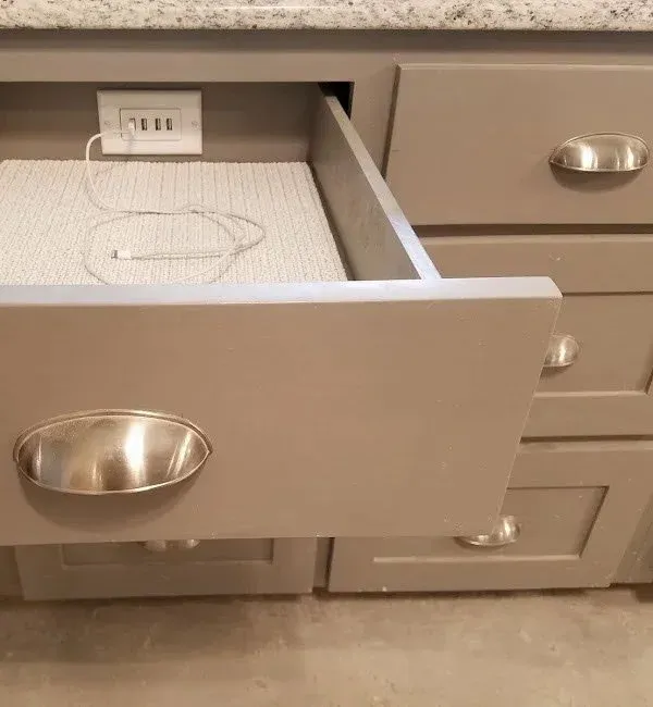 Drawer open to reveal integrated charging power strip with charging devices