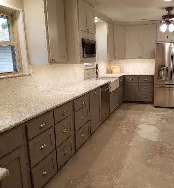 White fireclay farmhouse sink mounted in custom-reinforced base cabinet
