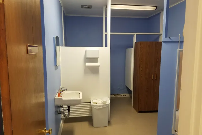 Bathroom gut renovation during demolition showing exposed studs and plumbing
