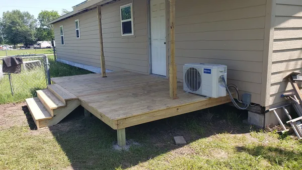 Stairs leading from wood deck to stone patio area