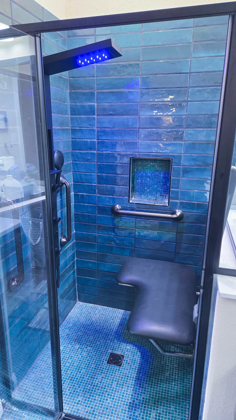 Fold-down safety shower seat installation in tile shower