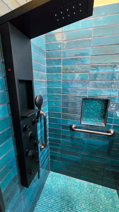 Shower seat folded up flush against tile wall